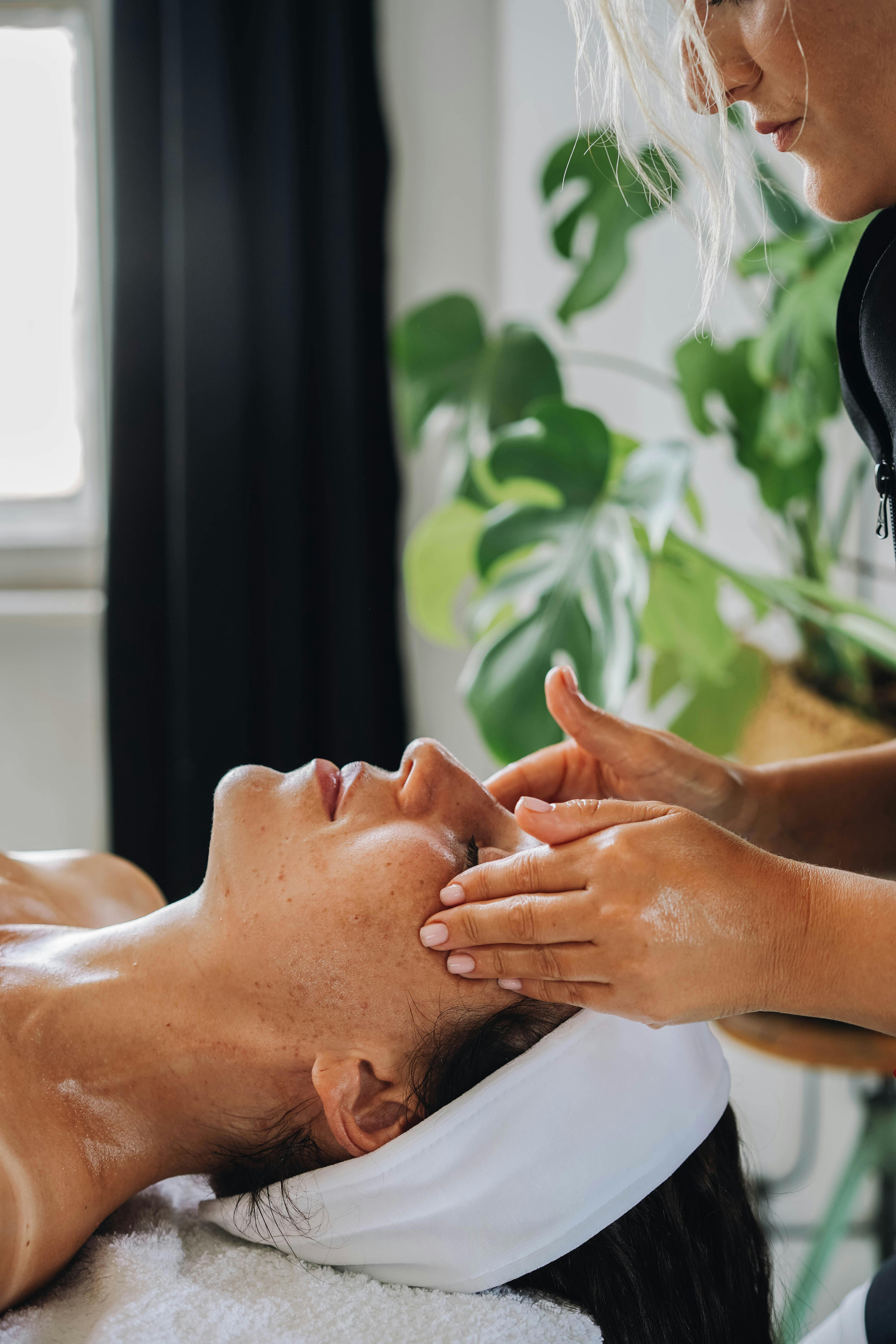 Woman receiving a calming facial massage at a wellness spa.